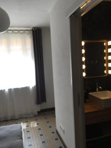 巴涅尔德比戈尔Charmant appartement sur cour, Le Cerisier的一间卧室,配有带水槽和镜子的浴室