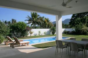圣斐利-银港Villa Deluxe Costambar的一个带桌椅的庭院和一个游泳池