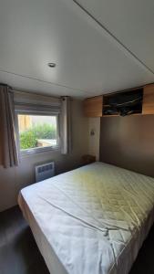加斯泰3 chambres mimizan gastes biscarrosse camping siblu的一间卧室设有一张大床和窗户
