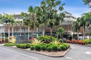 凯恩斯Shangri-La The Marina, Cairns的街道前方有棕榈树的建筑