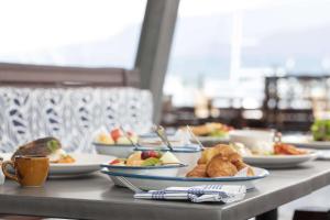 凯恩斯Shangri-La The Marina, Cairns的餐桌上放有食物盘子的桌子