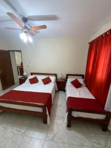 萨尔塔Departamento Urquiza的一间卧室配有两张床和吊扇
