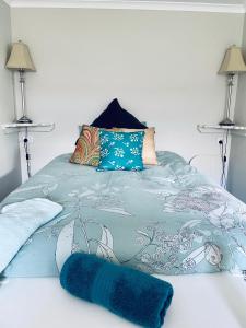 斯旺西Churchill's B&B twin spa getaway Studio的一张蓝色的毯子,躺在床上,有两盏灯