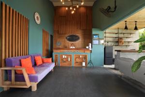 拉威海滩Tea Tree Boutique Resort的客厅配有紫色沙发和壁炉