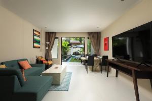 拉威海滩Tea Tree Boutique Resort的带沙发、电视和桌子的客厅
