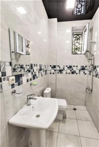 库塔伊西Mango's Guesthouse的白色的浴室设有水槽和卫生间。