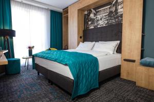 古梅尔斯巴赫Das Steinmüller Hotel的一间卧室配有一张带蓝色毯子的大床