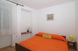 杜布罗夫尼克Dubrovnik Heritage Apartments的一间卧室配有一张带橙色毯子的床