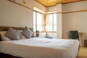 小谷村T Square Hakuba的卧室配有一张大白色床和窗户
