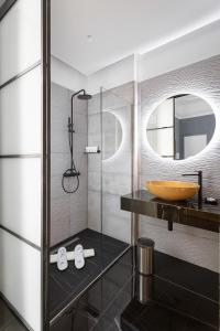 那不勒斯Hotel Poerio 25 Boutique Stay的一间带水槽和玻璃淋浴的浴室