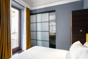 那不勒斯Hotel Poerio 25 Boutique Stay的一间带白色床的卧室和一间浴室