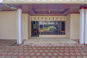 巴东Capital O 90643 Suri Guest House Syariah的两柱房子的门廊