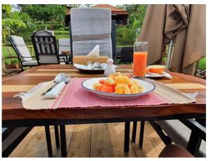 RwamaganaVintage Cottage的一张桌子,上面放着一盘水果和一杯橙汁