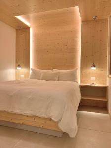 坎皮泰洛迪法萨欧式公寓的一间卧室配有一张大床和木制床头板