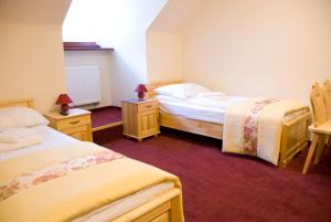 扎科帕内库兹尼采山地宾馆的一间卧室设有两张床和两个床头柜