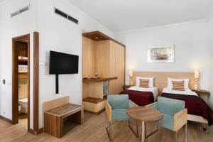 布达佩斯Hotel Bristol Budapest的一间酒店客房,设有两张床和电视