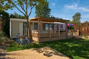 雷讷瑟Siblu Camping de Oase的小屋前面设有自行车停放处