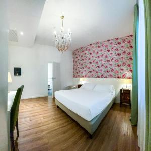 里米尼里米尼套房酒店的卧室配有白色的床和粉红色的墙壁