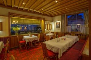 巴特塞京根弗吕酒店的餐厅设有2张桌子和椅子以及窗户。