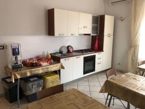 维博瓦伦蒂亚玫扎住宿加早餐旅馆的厨房配有白色家电、桌子和桌椅