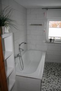 EggebekFerienhaus Frey的带窗户的浴室内的白色浴缸