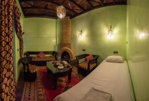 马拉喀什里亚德奥马尔庭院旅馆的一间卧室配有一张床,另一间设有壁炉。