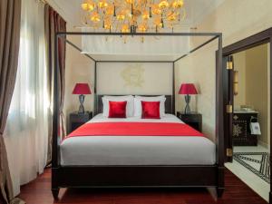 阿斯旺老卡塔拉特索菲特尔传奇酒店的一间卧室配有一张带红色枕头的大床