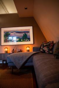 卑尔根Luxury apartment in Bergen's Gastronomic district的客厅配有沙发和墙上的绘画