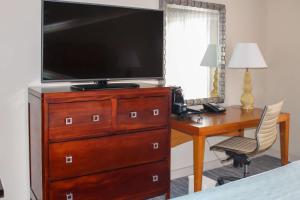 圣何塞优质瑞尔圣何塞酒店的卧室配有大电视,位于梳妆台上