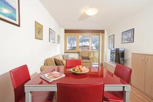 摩德纳迪-坎皮格里奥Apartment center Madonna di Campiglio EM的厨房以及带红色桌椅的用餐室。