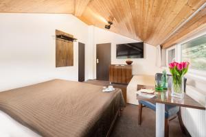 布尔诺乌素兰卡酒店的一间卧室配有一张床和一张鲜花桌子