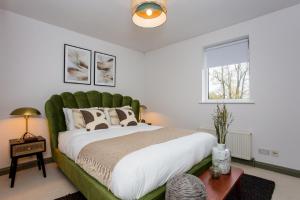 伦敦The Sparkford Gardens - Lovely 2BDR with Balcony的一间卧室配有一张大床和绿色床头板