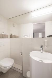 卢塞恩KoBi Boutique Studios Hirschenplatz的白色的浴室设有卫生间和水槽。