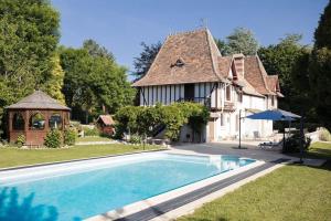 翁弗勒尔Demeure du Haut Canteloup的房屋前有游泳池的房子