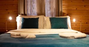 KettlebridgeThe Steadings Log Cabins的一张带两个枕头的床和两盏灯