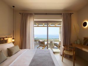 法纳里Collini Suites & Villas Mykonos的一间卧室配有一张床,享有海景