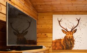 KettlebridgeThe Steadings Log Cabins的墙上一幅鹿与鹿的画