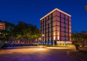 不莱梅Unique by ATLANTIC Hotels Bremen的一座高大的建筑,灯火照亮