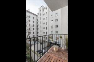 维也纳Operastreet City Center Apartment Brasil的白色建筑旁的阳台设有木甲板