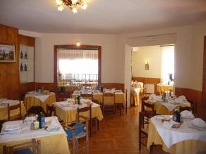 罗卡拉索阿尔贝尔格德索乐酒店的用餐室配有桌椅和黄色桌布