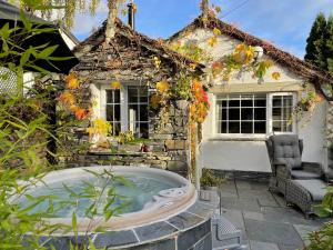 格拉斯米尔Marys Cottage, Grasmere, Dog Friendly, Hot Tub的房屋前的热水浴池