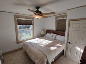 夏延Rancher's Capitol Lodge的一间卧室配有一张带吊扇和窗户的床。