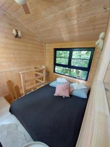 卡齐米日-多尔尼Węgiełek Treehouse的小木屋内一间卧室,配有一张大床