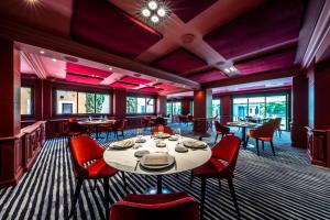 伯尼索米诺格Hôtel Baud - Teritoria的一间带桌子和红色椅子的用餐室