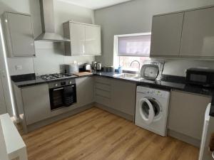 多切斯特Dorchester central flat的厨房配有洗衣机和水槽