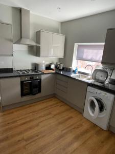 多切斯特Dorchester central flat的厨房配有水槽和洗衣机