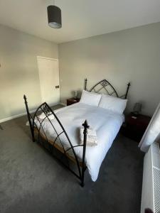 多切斯特Dorchester central flat的一间卧室配有黑色床和白色床单