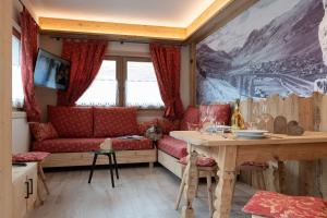 利维尼奥AG Apartments Livigno centro的客厅配有红色的沙发和桌子