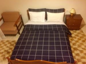 EllinikónGuesthouse "Athina"的一间卧室配有一张带 ⁇ 子毯子的床