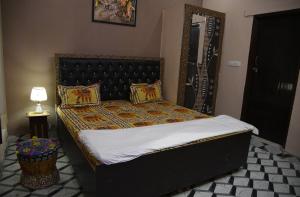 斋浦尔Laxmi Residence的一间卧室配有一张带黑色床头板的床